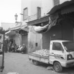 Black and white image of fruit on the bed of the truck waiting to be sold