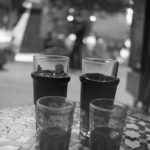 Black and white image of four glasses on a table