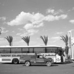 Black and white image of bus and truck next to each other