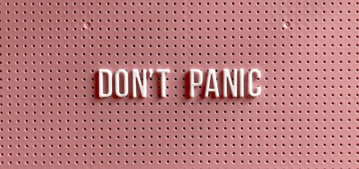 Image says don't panic in pink and white