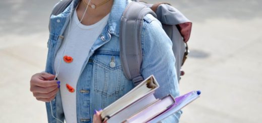 Student holding textbooks wearing backpack