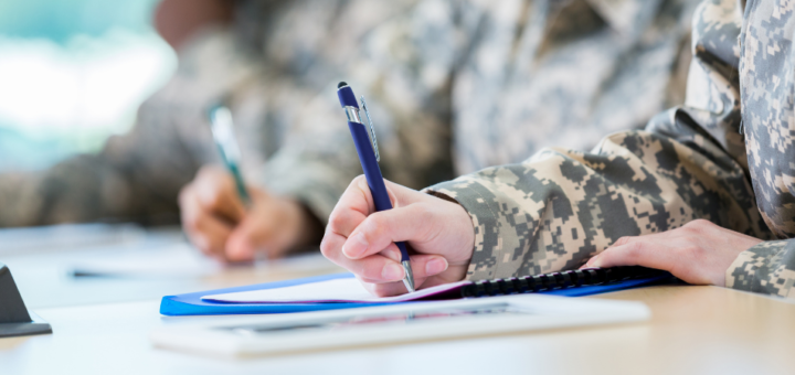 Image of people wearing military uniforms signing papers