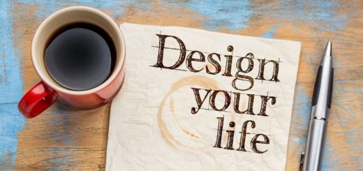 Image is a cup off coffee wit ha paper next to it that says design your life and a pen